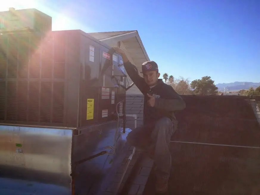 HVAC technician performing HVAC Inspection on a rooftop unit in Old Town